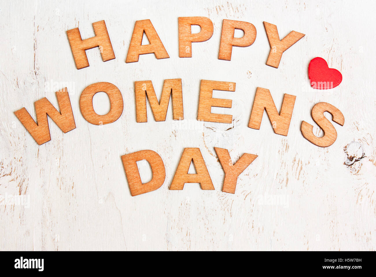 Happy Womens Day mit Holzbuchstaben auf einen alten weißen hölzernen Hintergrund Stockfoto
