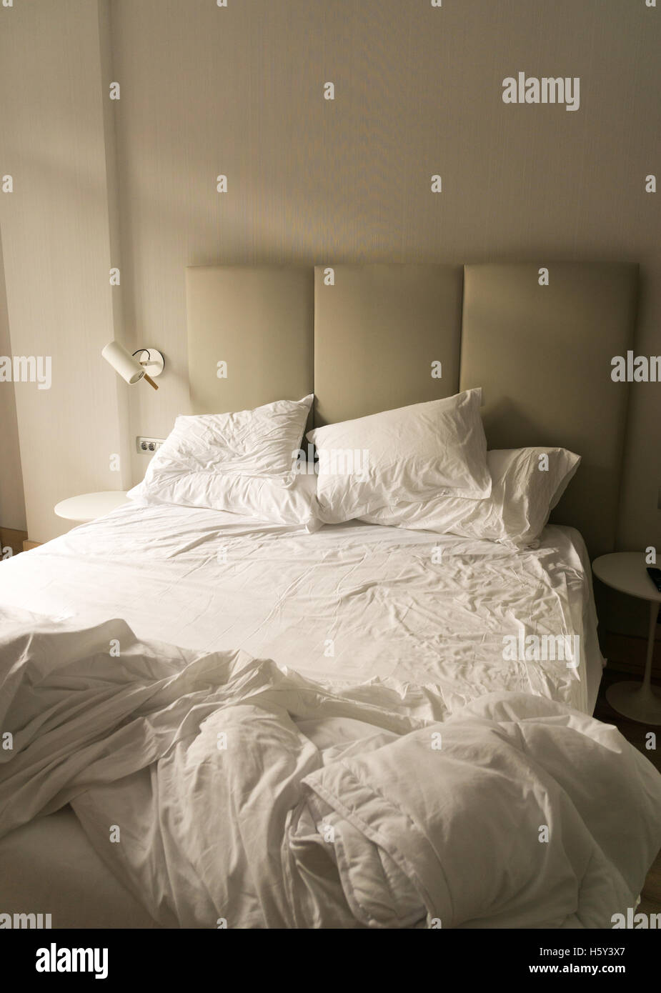 Ein ungemachtes Bett in einem Hotelzimmer Stockfoto