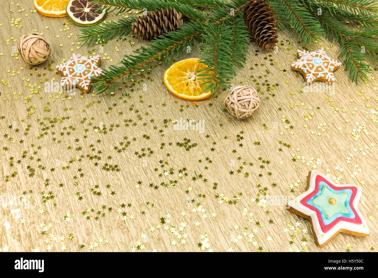 Weihnachtsschmuck und Lebkuchen auf goldenem Hintergrund Stockfoto