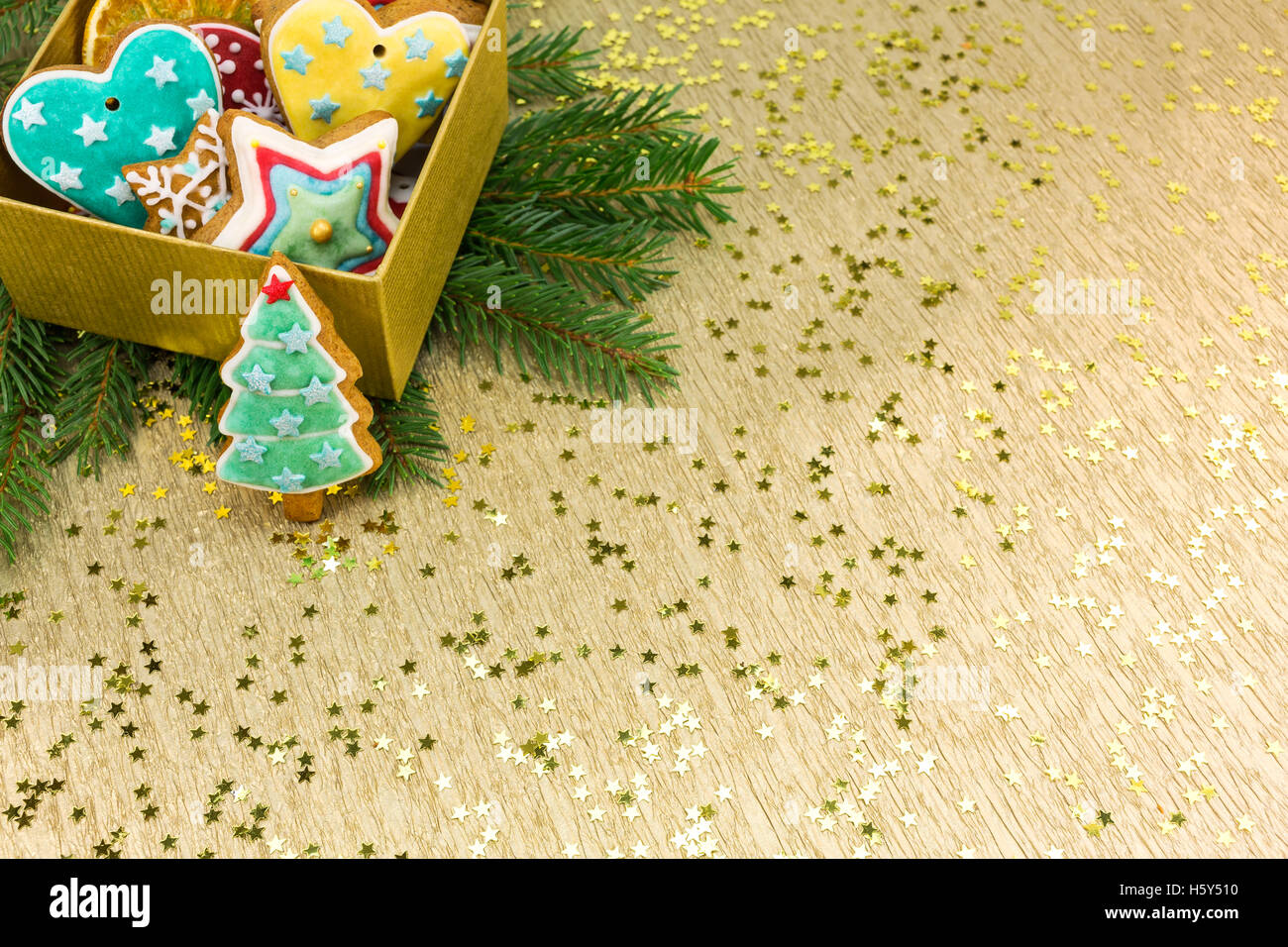 Weihnachten bunten Lebkuchen mit Tannenzweigen Baum auf Goldpapier Hintergrund Stockfoto