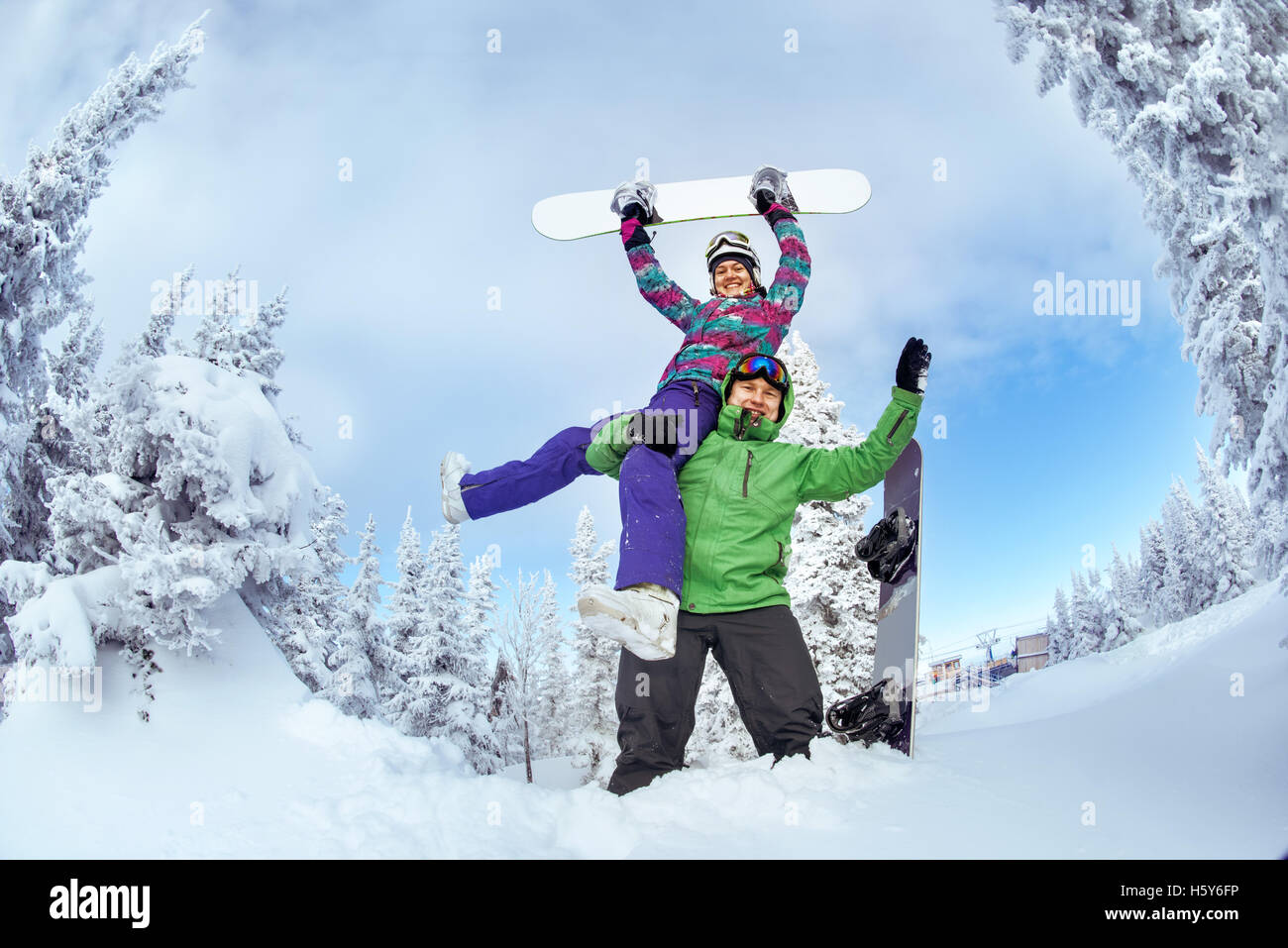 Snowboarder posiert auf blauen Himmel Hintergrund in Bergen Stockfoto