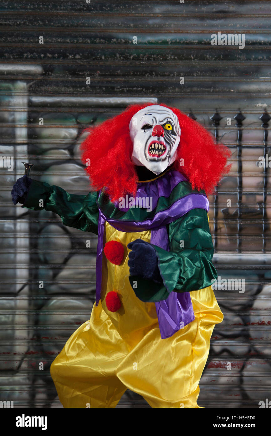 Ein killer Halloween Clown mit Maske, weißen Gesicht, rote Perücke, und  eine schreiende furchtsamen Ausdruck, Southport, Merseyside, UK  Stockfotografie - Alamy