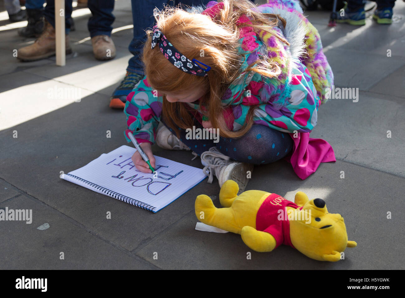 London, UK. 22. Oktober 2016. Ella, 6 Jahre, aus Farnham, mit ihrer Botschaft nicht zu kämpfen. Mehrere Hundert Aktivisten inszeniert eine "Speichern der Kinder von Aleppo" außerhalb Downing Street fordert PM Theresa May die Regierung des Vereinigten Königreichs Anstrengungen, um das Leiden der Zivilbevölkerung in der belagerten syrischen Aleppo zu beenden. Insgesamt wurden 200 Bären aufgestapelt außen Downing Street, markieren die Zahl der Kinder, die in Aleppo seit Mitte September ein Waffenstillstand brach getötet. Es werden gedacht, um rund 100.000 Kinder derzeit noch in östlichen Aleppo gefangen werden. © Bettina Strenske/Alamy Liv Stockfoto