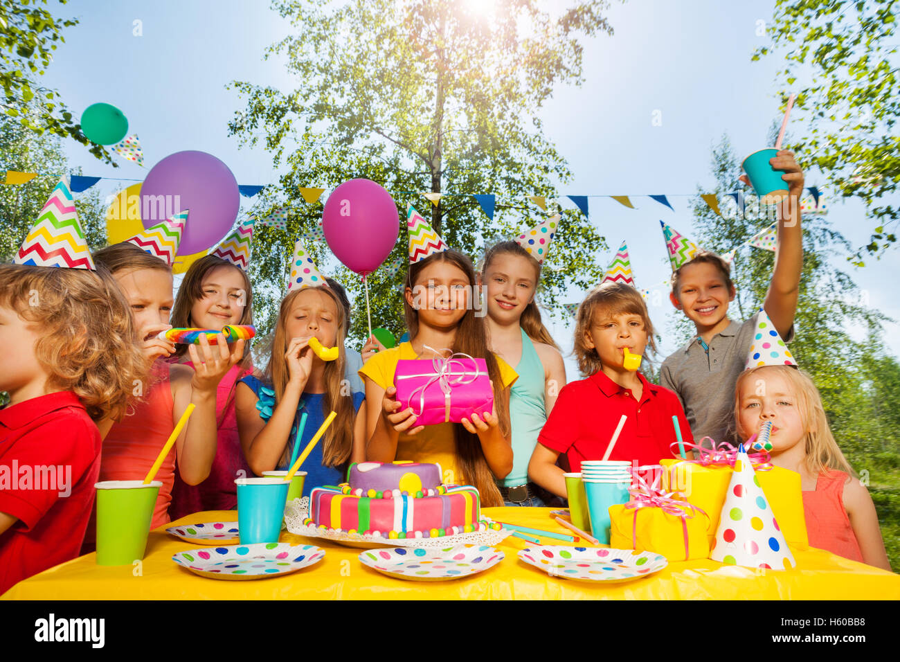 Lustige Kinder jubeln Geburtstagskind im Sommerpark Stockfoto
