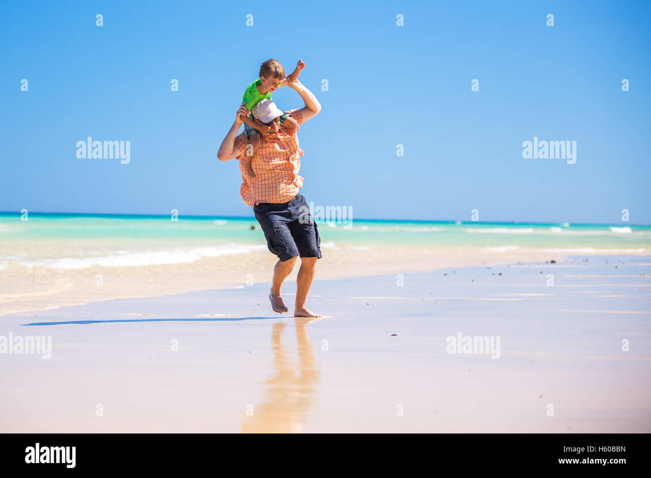 Vater und seinen kleinen Sohn mit Spaß und läuft auf den Strand. Stockfoto