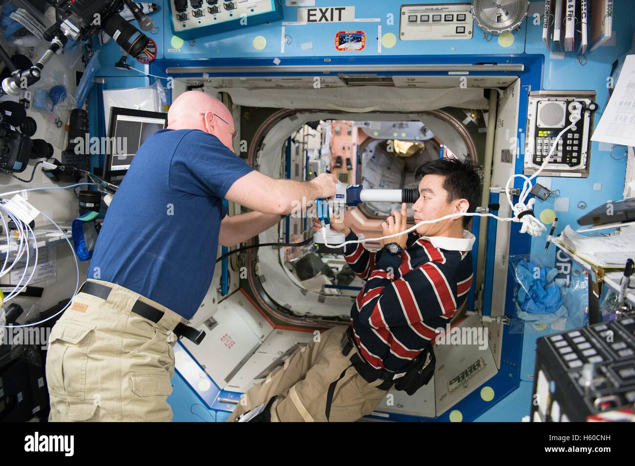 NASA internationale Raumstation ISS-Expedition 44 Mission Astronaut Scott Kelly unterstützt japanischen Astronaut Kimiya Yui der Japan Aerospace Exploration Agency in retinalen Bilder für eine laufende Ocular Gesundheitsstudie 5. August 2015 in der Erdumlaufbahn. Stockfoto
