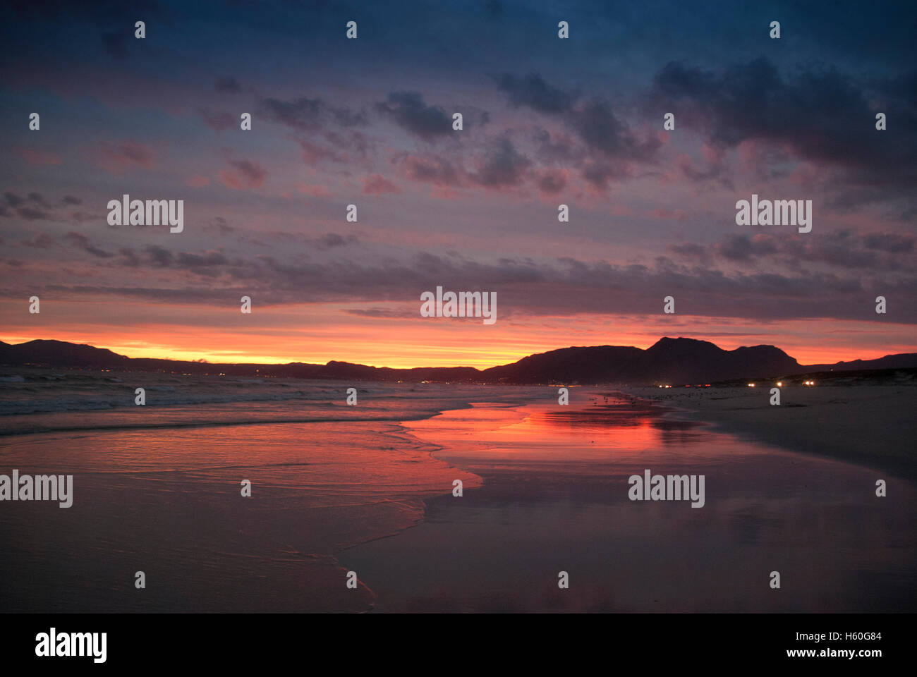 Sonnenuntergang am Strandfontein Strand mit Blick auf Muizenberg. Stockfoto