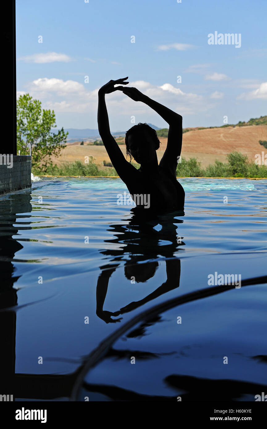 Die Silhouette einer Frau in den thermal-Innenpool von Fonteverde Natural Spa Resort in San Casciano dei Bagni, in der Nähe von Siena. Stockfoto