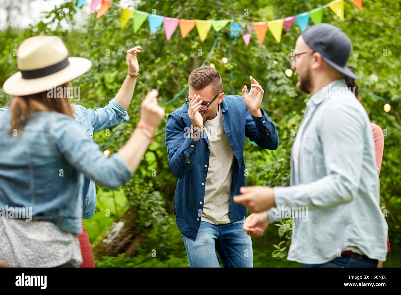 Glückliche Freunde tanzen am Sommerfest im Garten Stockfoto
