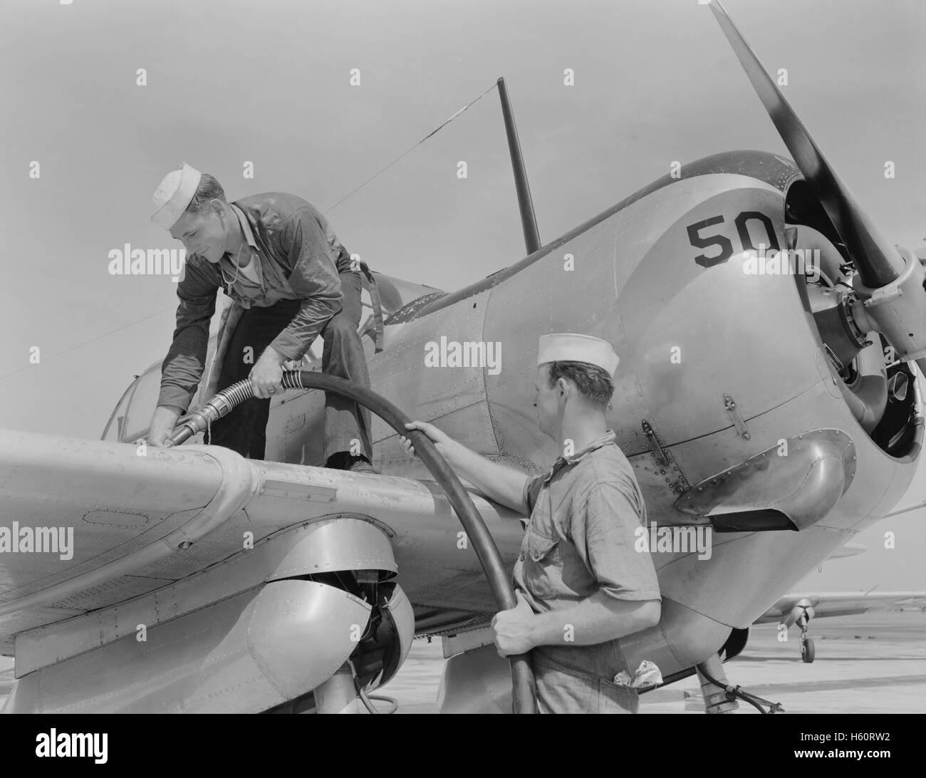 Sailor Mechanics füllt das Flugzeug mit Benzin auf dem Marinestützpunkt Corpus Christi, USA, Howard R. Hollem, USA Office of war Information, August 1942 Stockfoto