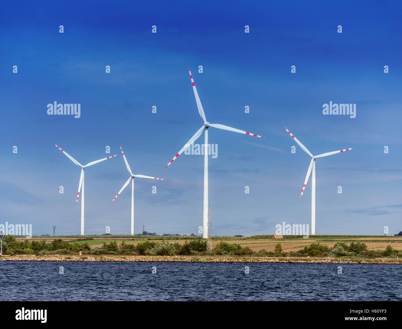 Vier Windkraftanlagen gegen blauen Himmel Stockfoto