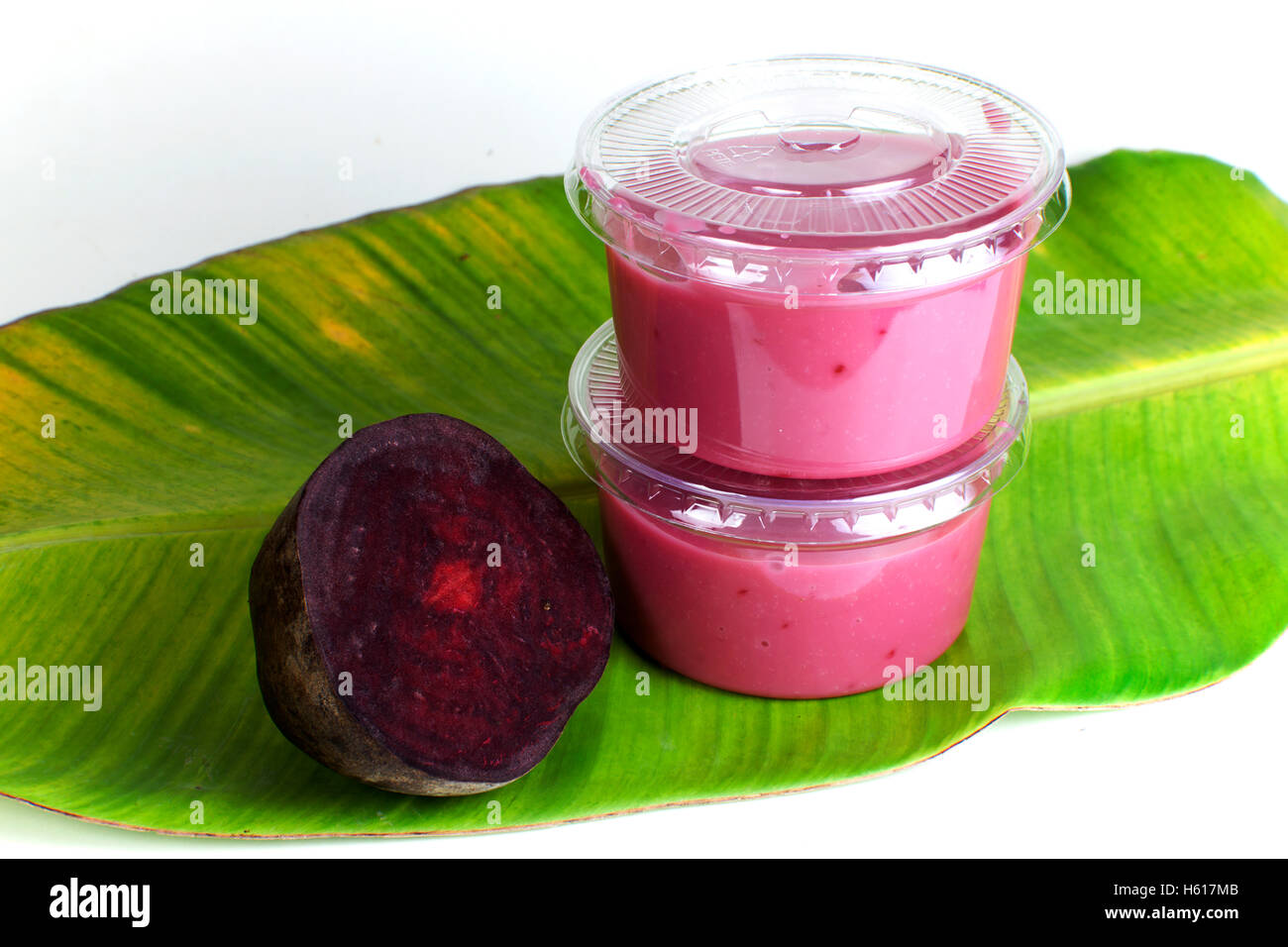 Rote Beete Salat-Dressing-Mix in einer Plastikflasche auf einem Bananenblatt auf weißem Hintergrund Stockfoto