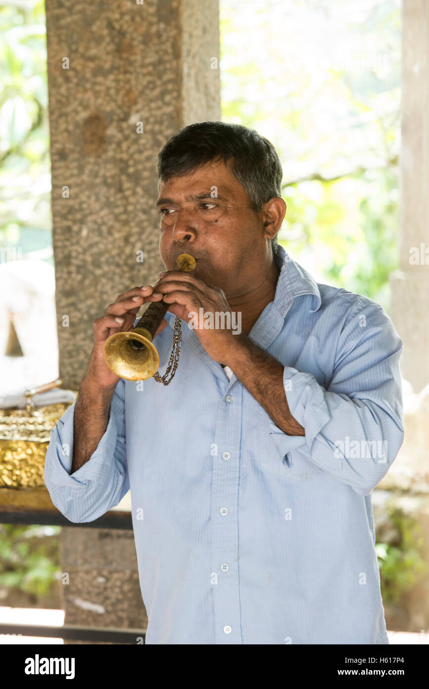 Mann bläst einen traditionellen Horn am Puja, Lankatilake Tempel aus dem 14. Jahrhundert, Kandy, Sri Lanka Stockfoto