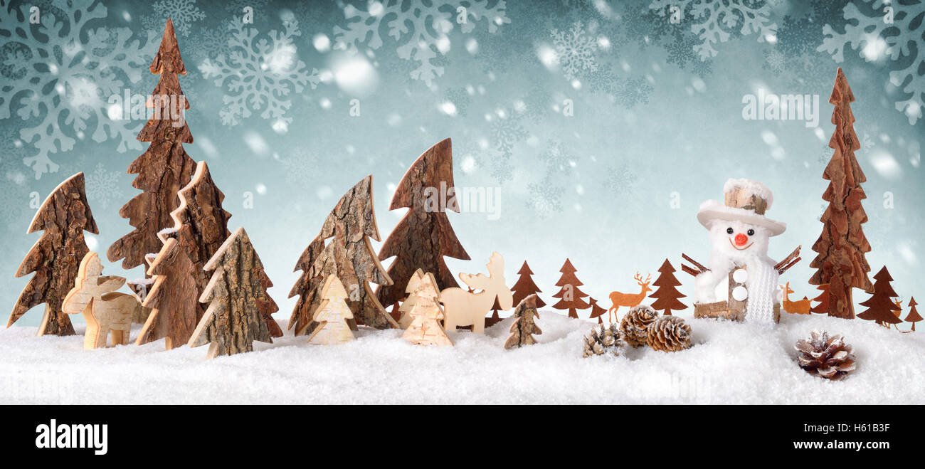 Dekoration aus Holz als eine niedliche Winterszene mit einem Schneemann, Nadelbäume, Weihnachtsstern, Tiere und Schnee, auf einem Snowflak angeordnet Stockfoto