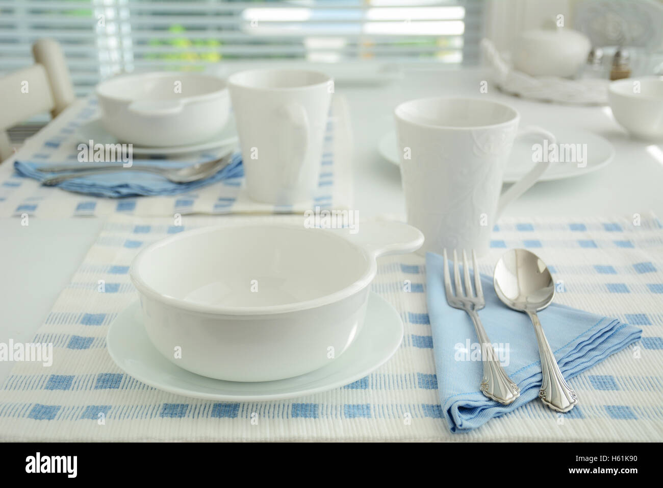 Blaue und weiße erstellen Sie eine einfache, elegante Tischdekoration.  Äußerst geringe Schärfentiefe.  Gedreht in natürlichem Licht. Stockfoto