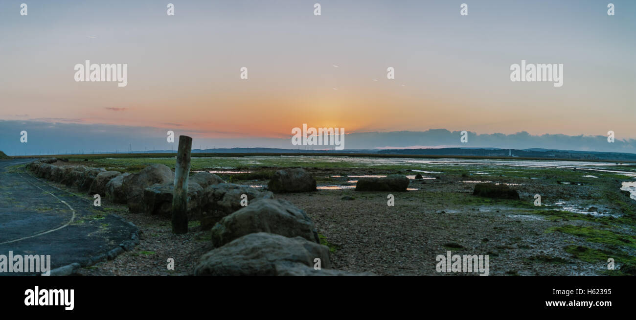 Höchststand von Sonnenaufgang Wolken schleichende entfernten Panorama Dorset Strand keyhaven Stockfoto