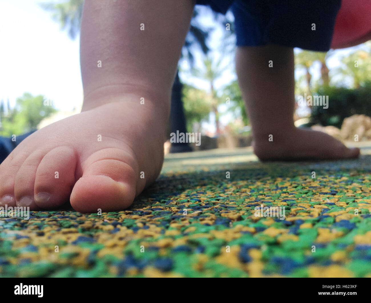 11 Monate altes Baby junge Füße über Playpark Gummiboden Stockfoto