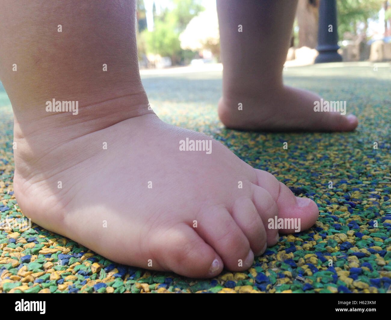 11 Monate altes Baby junge Füße über Playpark Gummiboden Stockfoto