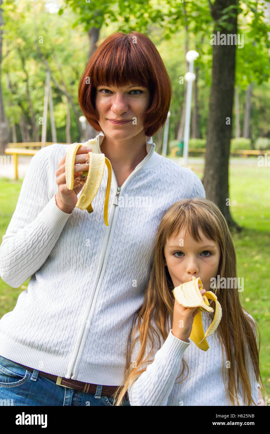 Foto von Mutter und Tochter Banane essen Stockfoto