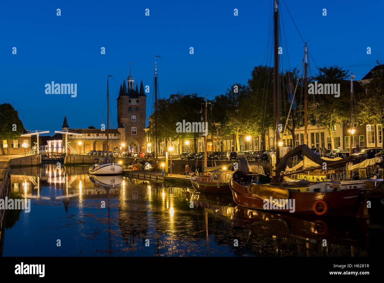 Zierikzee, Niederlande - 5. Oktober 2016: Hafen mit alten Schiffen und Zuidhavenpoort in der Nacht an der Oude Haven in Zierikzee. Stockfoto