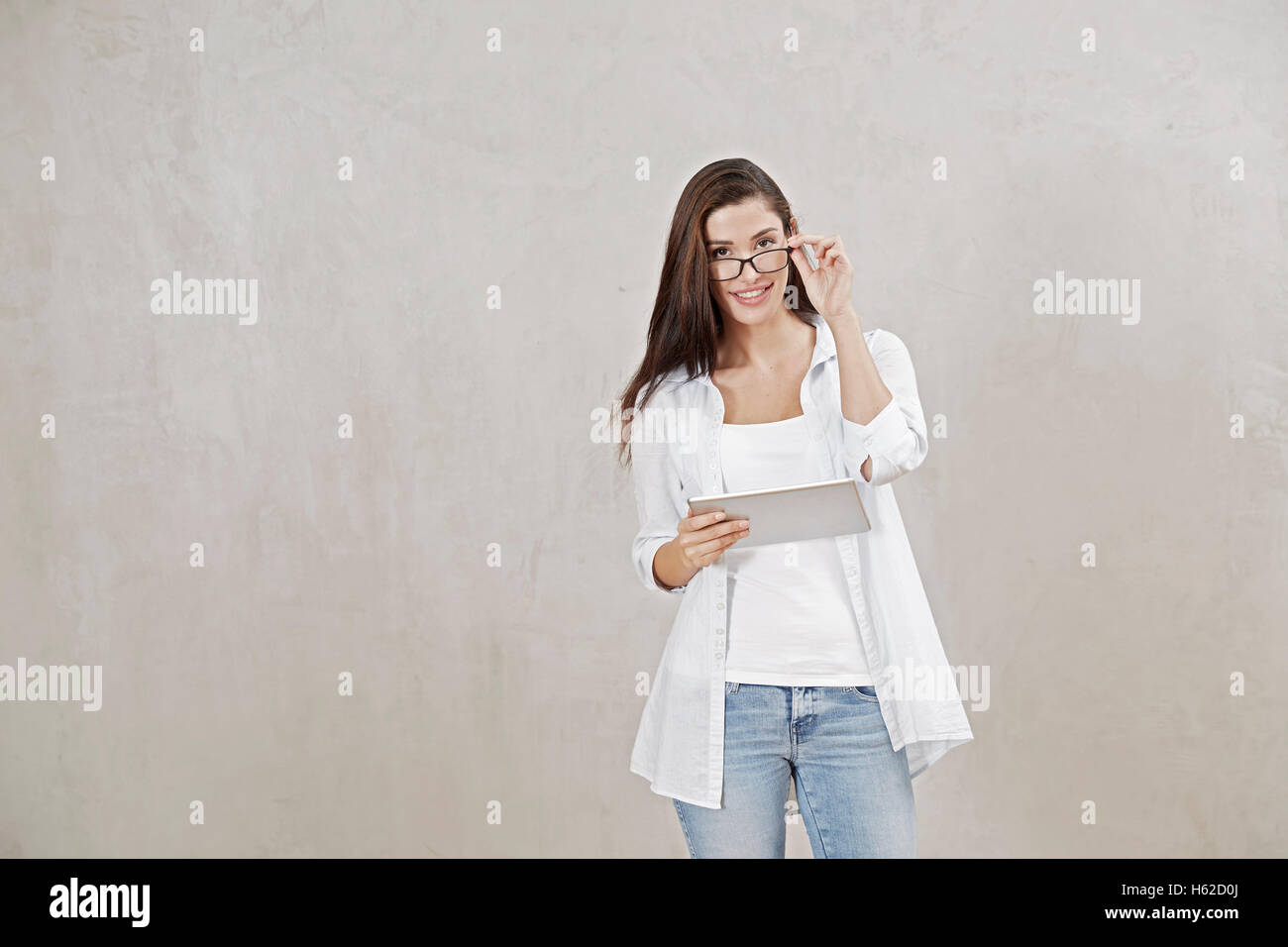 Porträt der lächelnde junge Frau mit Brille und tablet Stockfoto