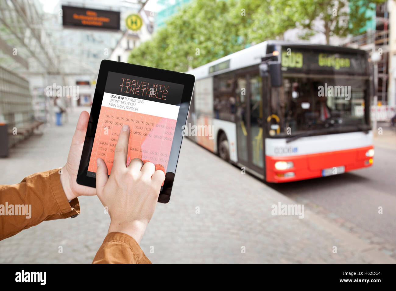 Hand, die eine digitale Tafel mit Bus Fahrplan an Bushaltestellen Stockfoto