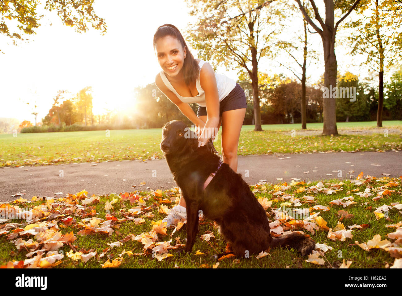 Frau bei einem Spaziergang mit ihrem Hund im Herbst Stockfoto