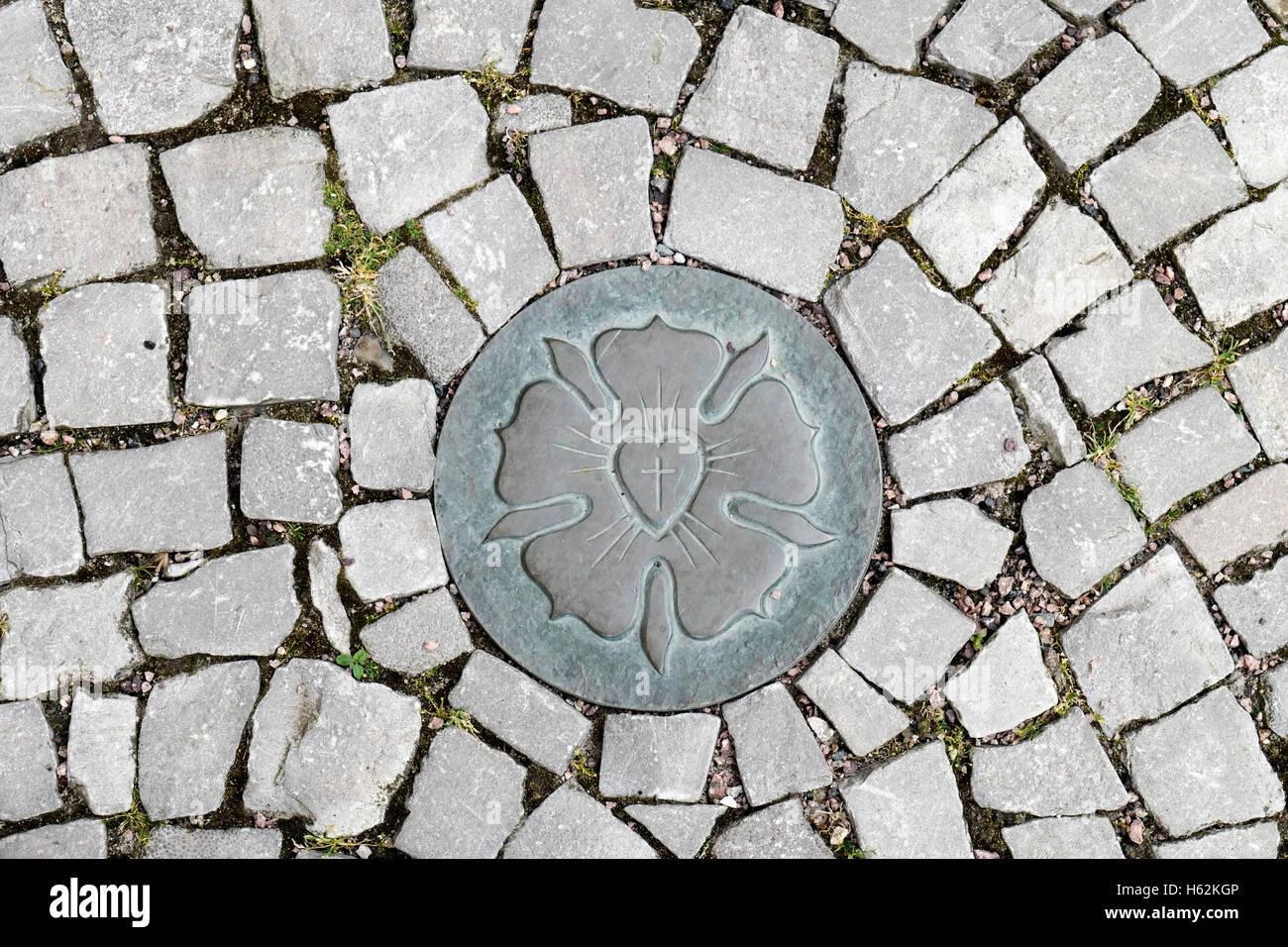 Eine Luther-rose ist auf dem Bürgersteig von Eisleben, Deutschland, 20. Juni 2016 ersichtlich. Die Luther-rose ist das Symbol der Evnagelical-lutherischen Kirche und das Siegel der Martin-Luther Briefe ab 1530. Foto: Peter Endig Stockfoto
