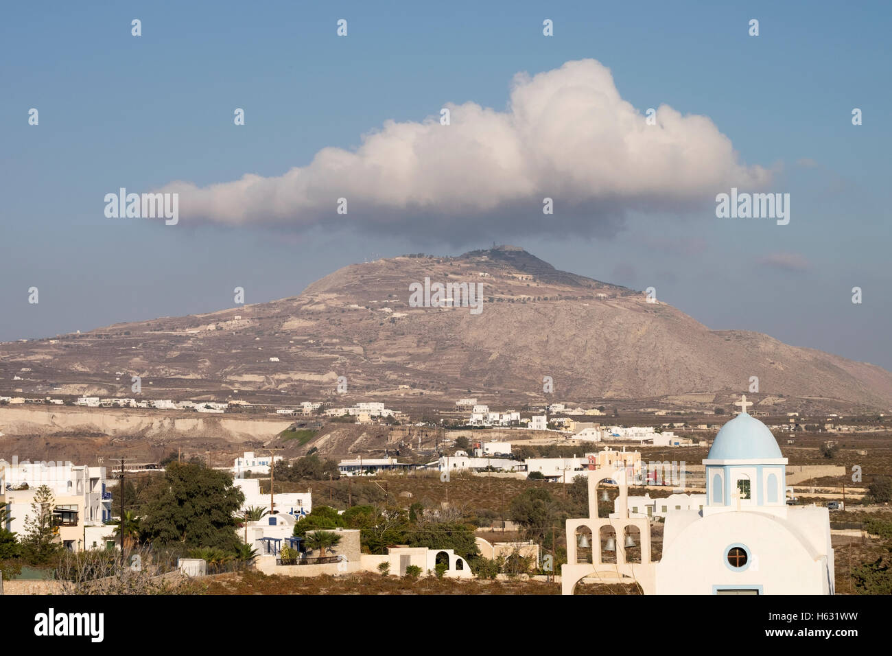 Eine Wolke schwebt über dem höchsten Punkt auf der Insel Santorin in Griechenland. Stockfoto