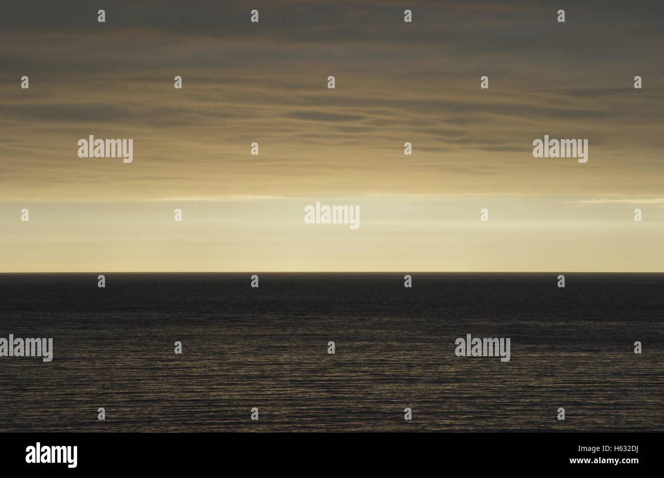 Eine arty / moody Aufnahme des Horizonts, mit einer dicken geraden sandigen aussehenden Wolke nahe am Meer. Aberystwyth. Stockfoto