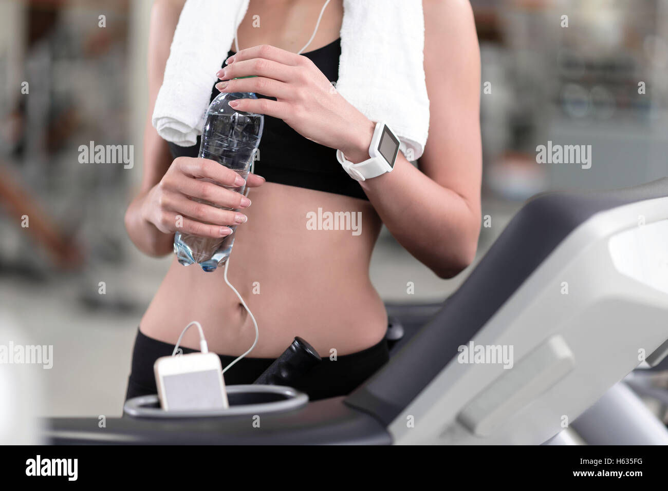 Schlankes Girl mit einer Flasche Wasser nach dem Training Stockfoto