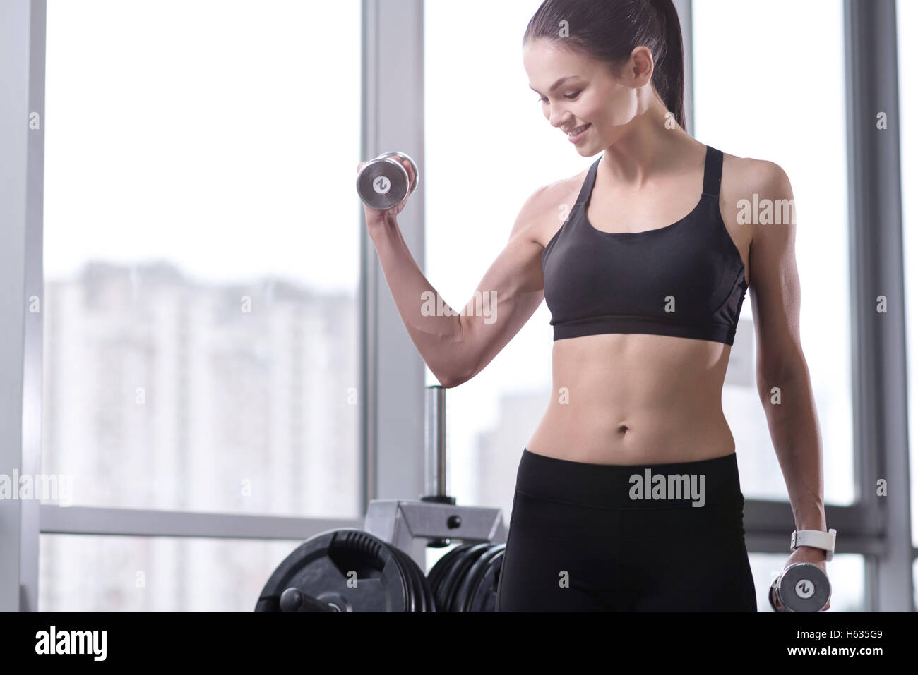 Aktive Mädchen Aufbau ihrer Muskeln in einem Fitnessstudio Stockfoto