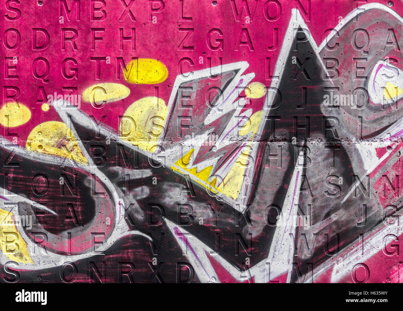 Graffiti an einer rosa Wand mit Alphabet eingraviert im Hintergrund Stockfoto