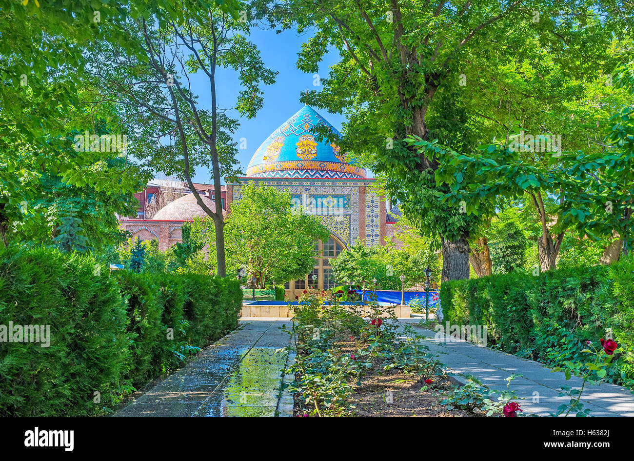 Die schattige Allee des Gartens führt zur blauen Moschee Shia, perfekt eingerichtet, mit bunten Kacheln, Yerevan, Armenien. Stockfoto