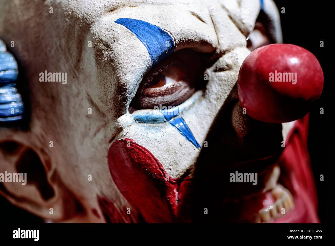 Nahaufnahme eines unheimlich böse Clown mit seinem Mund geöffnet und zeigt seine verfaulte Zähne, starrte auf den Betrachter Stockfoto