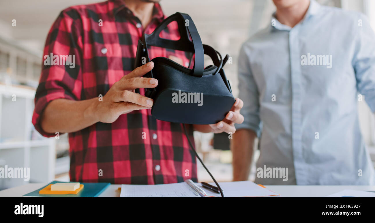 Aufnahme von zwei jungen Männern, die virtual-Reality-Kopfhörer im Büro testen abgeschnitten. Business-Männer arbeiten am Schreibtisch mit VR-Brille. Stockfoto