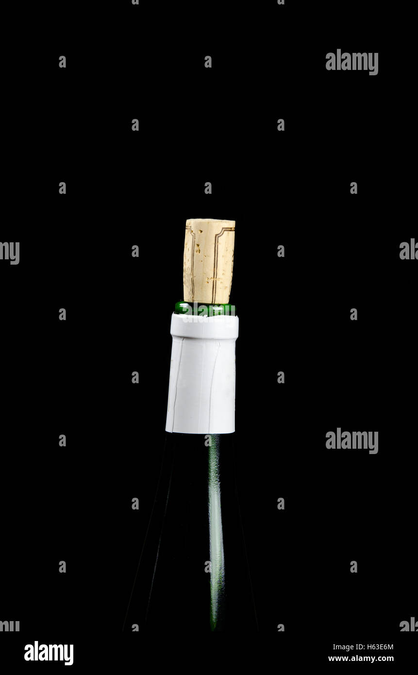 Grüne Weinflasche oben mit einem sichtbaren Korken auf schwarzem Hintergrund Stockfoto