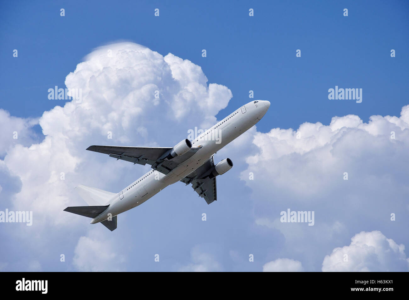 Flugzeug ist unter flauschigen Wolken am blauen Himmel abheben Stockfoto