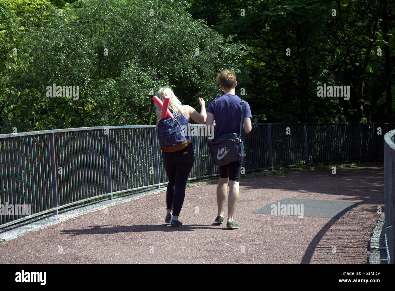 Junge Paare, die glücklich auf Brücke Fußgänger Glasgow, Schottland Stockfoto