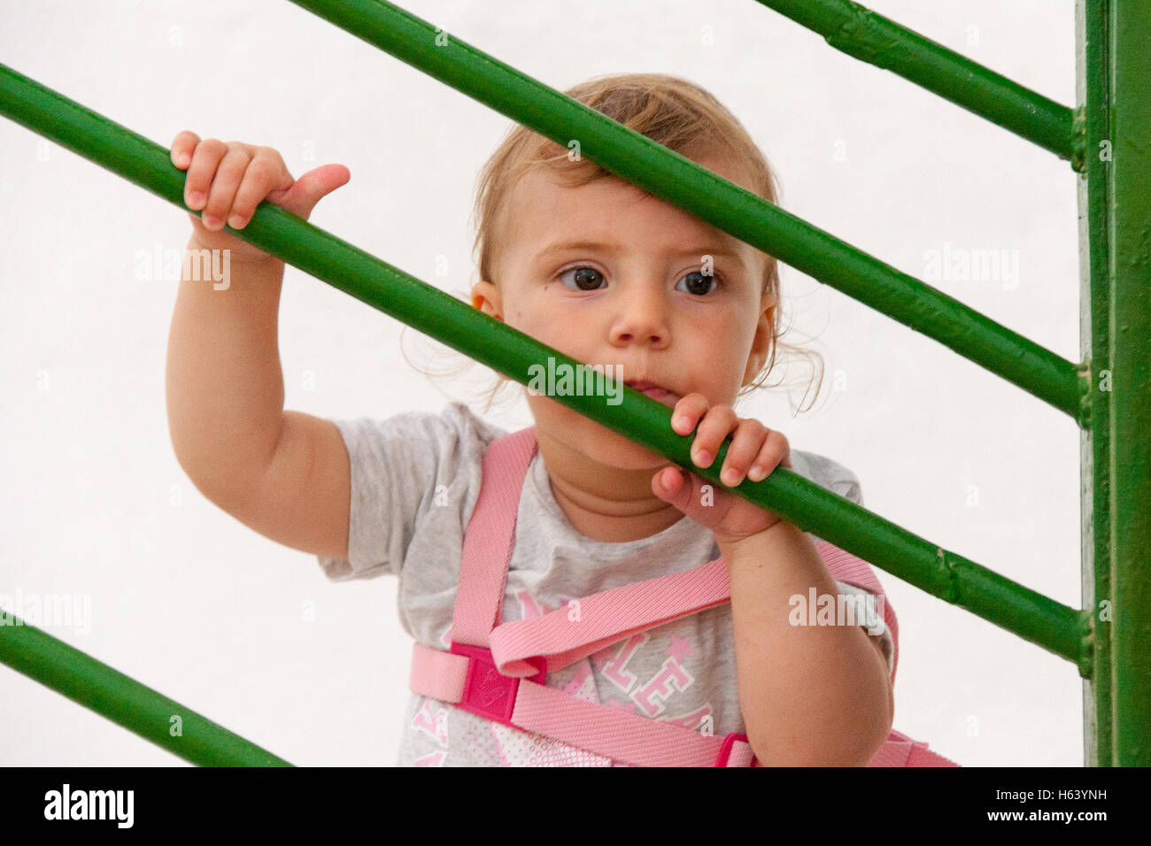 kleines Kind durch Treppengeländer Stockfoto