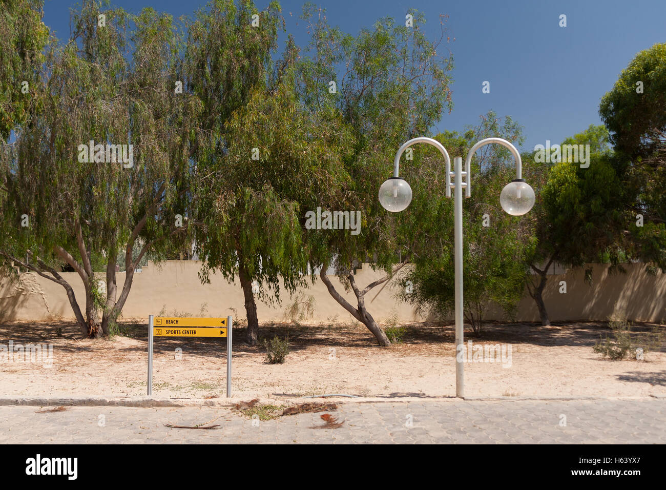 Laternenpfahl und Schild mit Bäumen im Ferienort Stockfoto
