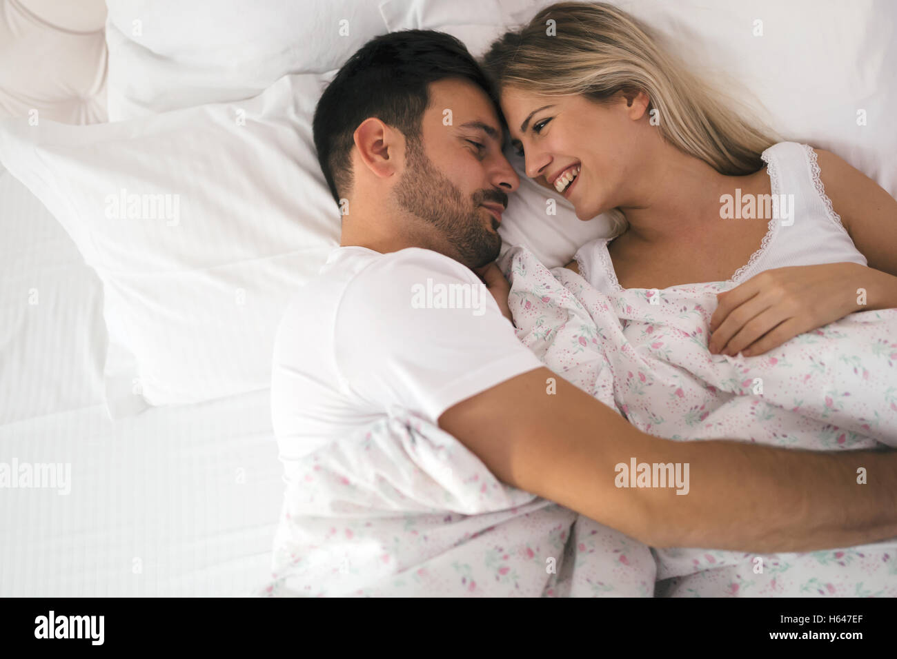 Romantisch zu zweit im Bett in Nachtwäsche lächelnd Stockfoto