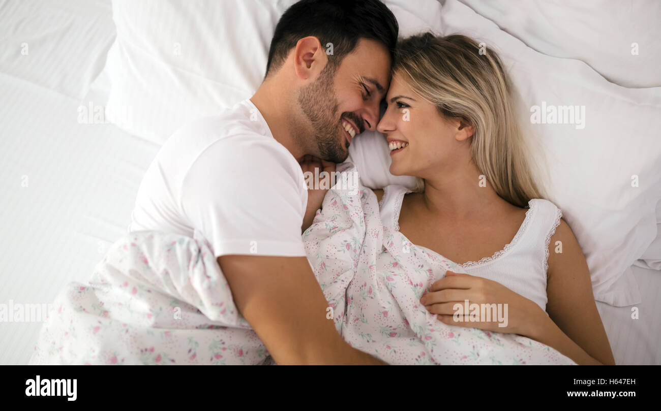 Romantisch zu zweit im Bett in Nachtwäsche lächelnd Stockfoto