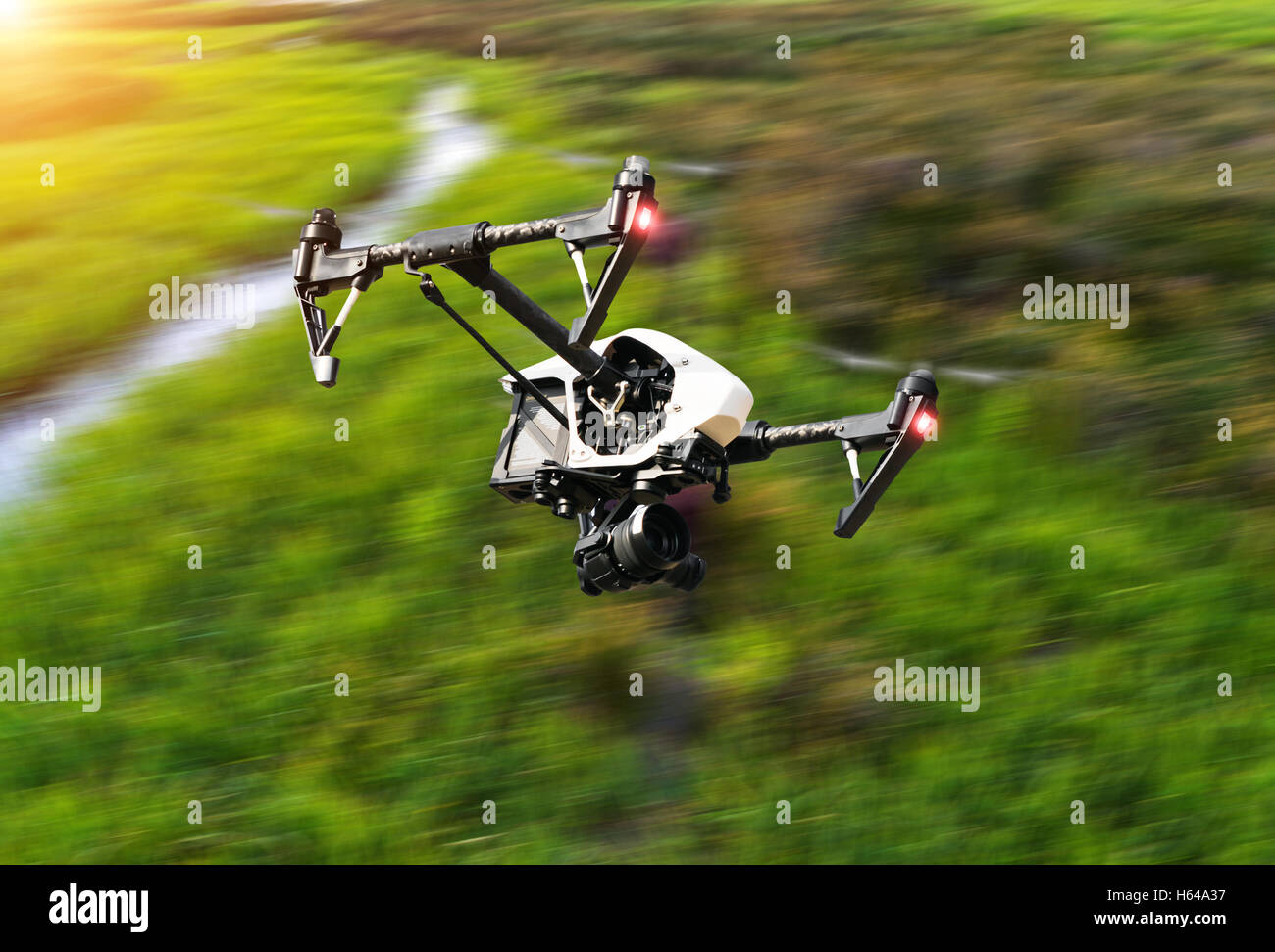 Drohne fliegen über grüne Wiese in Unschärfe Bewegung Stockfoto