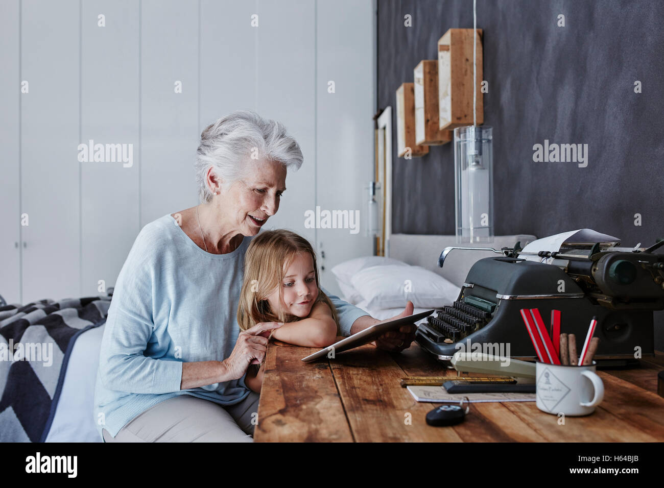 Großmutter und Enkelin Blick auf Tablet zu Hause Stockfoto