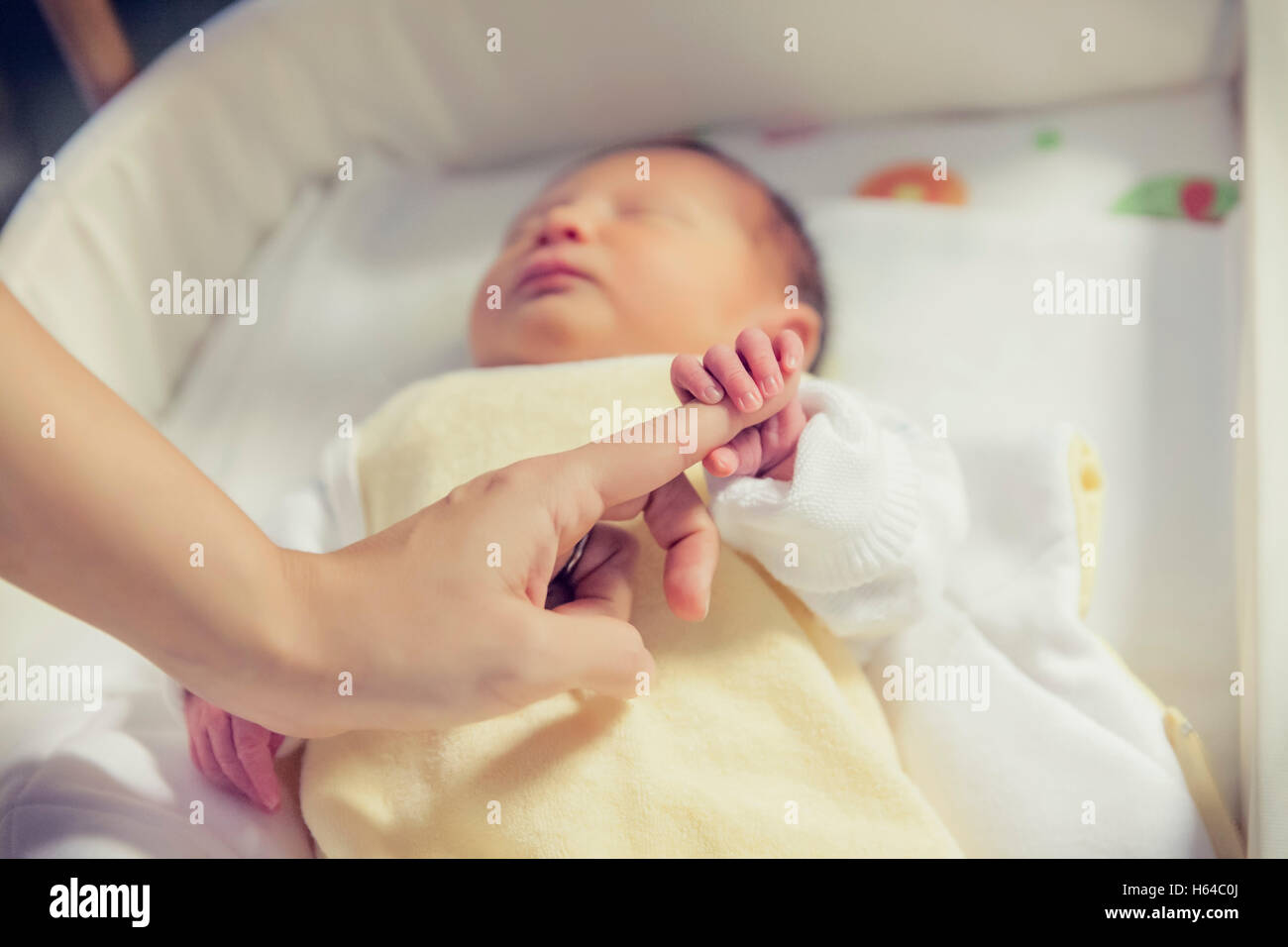 Hand des Neugeborenen halten Finger im Krankenhausbett Stockfoto