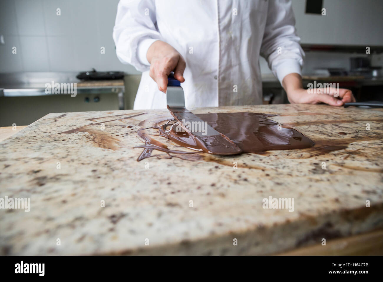 Frau, die geschmolzenen Schokolade auf einem Marmor Oberfläche Härten Stockfoto