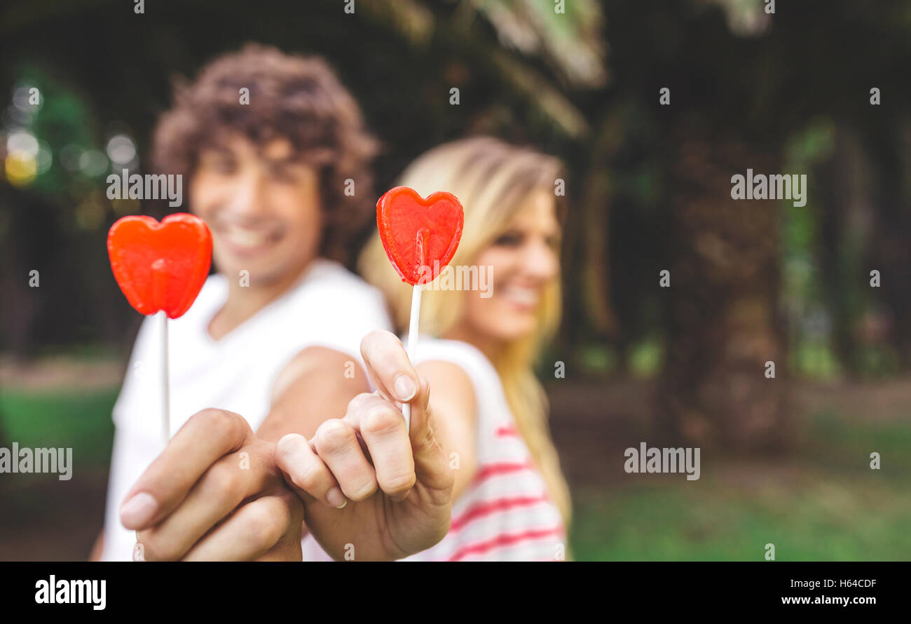 Junges Paar Holding herzförmigen Lutscher Stockfoto