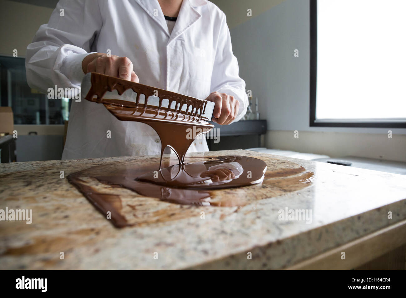 Frau, die geschmolzenen Schokolade auf einem Marmor Oberfläche Härten Stockfoto