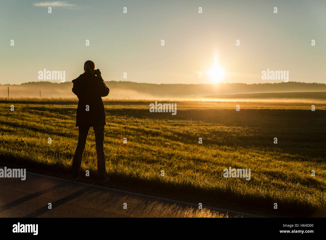 Deutschland, Bayern, Frau Sonnenaufgang fotografieren Stockfoto